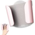 Wall-mounted silicone shower hair catcher installed on a tile shower wall