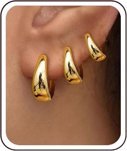 Gold huggie hoop earrings worn on the ear